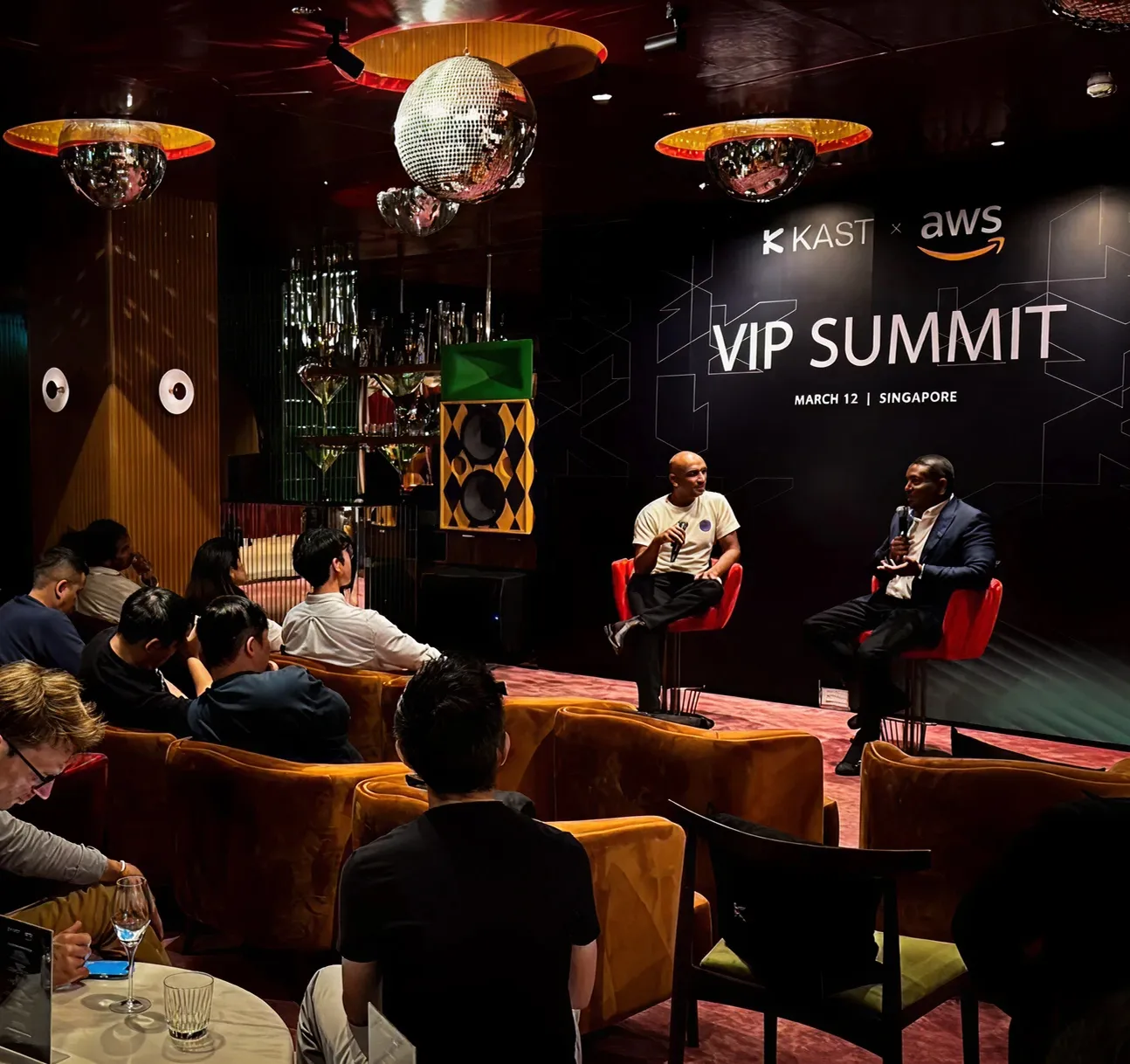 Founders seated at a KAST and AWS VIP Summit in Singapore, watching a fireside conversation on stage.